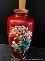 Full view of red cloisonné floral vase next to ruler