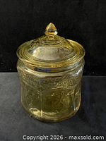 Full view of amber pressed glass jar with lid