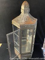Cabinet with door open showing glass shelves and ornate metal frame