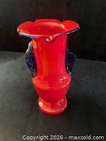 Front view of red-orange vase with blue-green trim and side handles