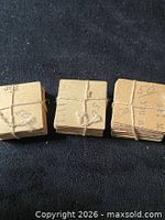 Front view of three tied bundles showing blank reverse sides