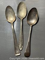 Three assorted silver-plated spoons front view