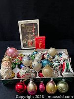 Overview of lot showing storage tray filled with assorted glass ornaments, Santa head, nutcracker, boxed chimes and candles