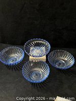 Four pieces laid out: three small bowls and one footed dish