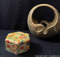 brass swan planter beside floral hexagonal box