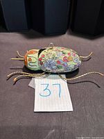 side view showing enamel detail, metal legs and bail