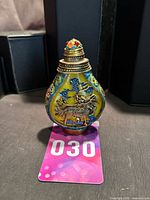 Front view of cloisonné snuff bottle showing dragon on yellow enamel panel