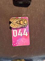 Top view of carved cicada pendant on measurement card