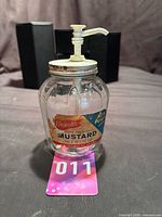 Front view of glass jar with label and pump