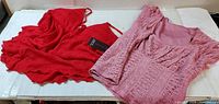 Red and pink blouses laid flat showing full view