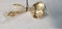 Two large gold-tone serving spoons wrapped together