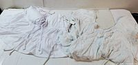 Two white blouses laid out flat showing styles and color