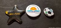 Front view of three pinback buttons: star, Catholic Schools, soccer ball