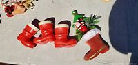 Four red plastic boot ornaments, three plain, one decorated