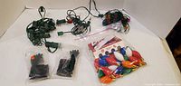 Overall lot showing five green-wire light strands, bag of gloves and bag of multicolour C9 bulbs