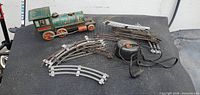 Top view of locomotive, transformer, and assorted track pieces spread on table