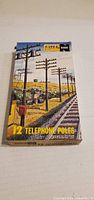Front view of Atlas N Scale 12 Telephone Poles box