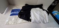 Overall lot view showing black shorts, white Adidas shirt, sealed Avon package