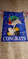 Full view of blue flag showing cat graphic and CONGRATS text