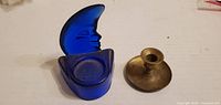Front view of blue glass crescent moon votive holder and brass candle holder
