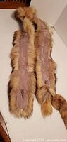 Pair of brown fur stoles underside showing mauve satin lining and tails