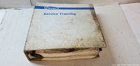 Closed binder front showing Carrier Service Training title and soiled cover