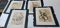 All four mounted caricature prints on tabletop