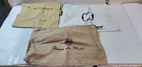 Overview of three cloth protector bags: Burberry, Made in Italy, Hinnesy La Mada