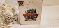 Hallmark Keepsake Noah's Ark box front and white Santa ornament in wrap