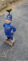 front view of ceramic policeman lamp showing uniform details, brass fixture, cord