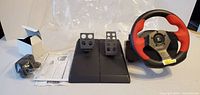 Complete set showing steering wheel, pedal unit, adapter, manuals