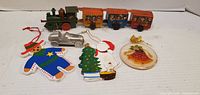 Overall lot showing locomotive, three passenger cars, metal car and four ornaments