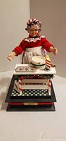 Front view of Mrs. Claus figure on base with baking scene