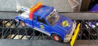 Overall view of blue Sunoco tow truck with yellow plow attached