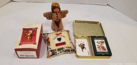 All four items: boxed Tigger ornament, wooden angel, quilted pillow, open tin with two decks