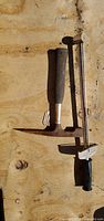 Both tools laid out: Topque bar upright beside rock pick hammer