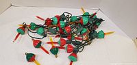 Full view of tangled bubble light string showing red/green bases and yellow tubes