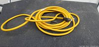 Overall view of coiled yellow extension cord on surface