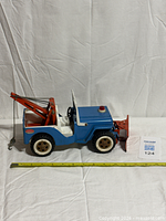 Left side view showing blue body, orange boom, white interior, snow plow, Tonka decal