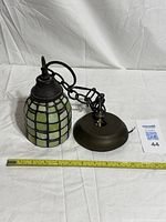 Full view of pendant light with chain, shade, canopy and ruler for scale