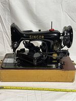 Left-side view of Singer 99K on carry case base with foot pedal and power cord