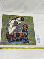 Front view of square ceramic tile with measuring tape indicating size