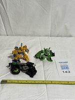 Group shot of three Transformer toys with measuring tape