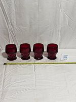 Four ruby red Viking Georgian tumblers lined up with measuring tape