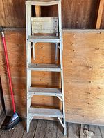 Front view of aluminum 4-step ladder showing overall structure and condition