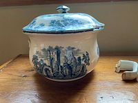 Chamber pot front showing scenic transferware design and damaged rim