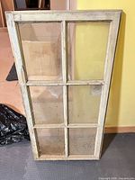 Full view of antique wooden sash window showing six panes and weathered paint