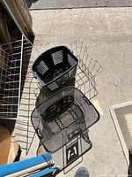 two black wire mesh baskets nested, one black plastic slotted basket, one silver wire folding basket
