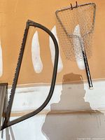 Bow saw and landing net hanging on wall