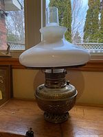 Full view of brass oil lamp with milk glass shade and chimney